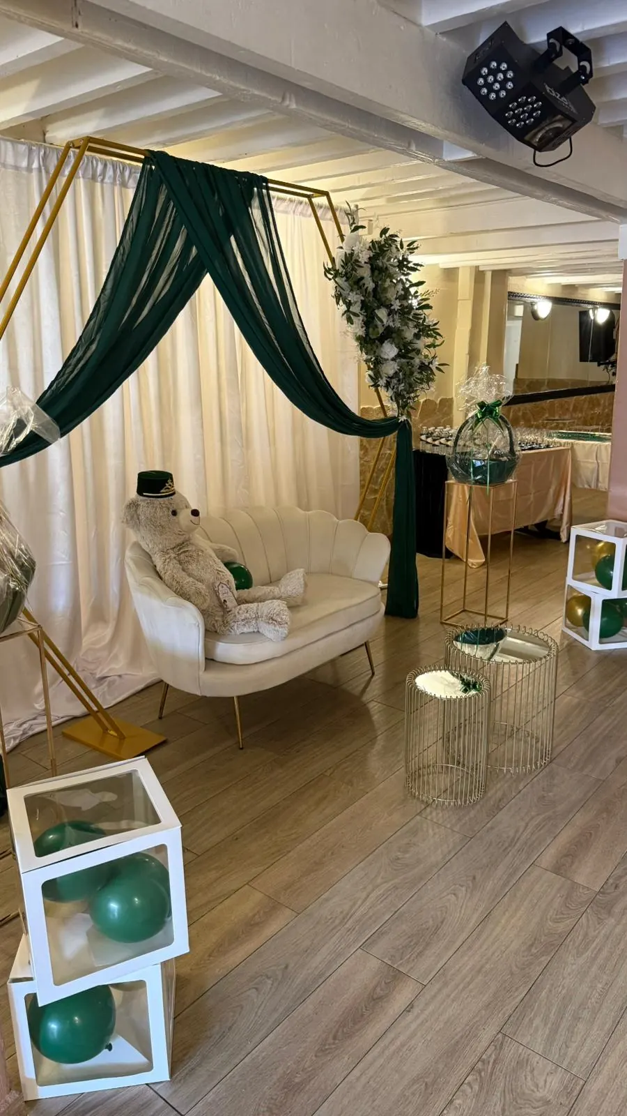 Coin photo avec drapé vert et fauteuil pour un baptême